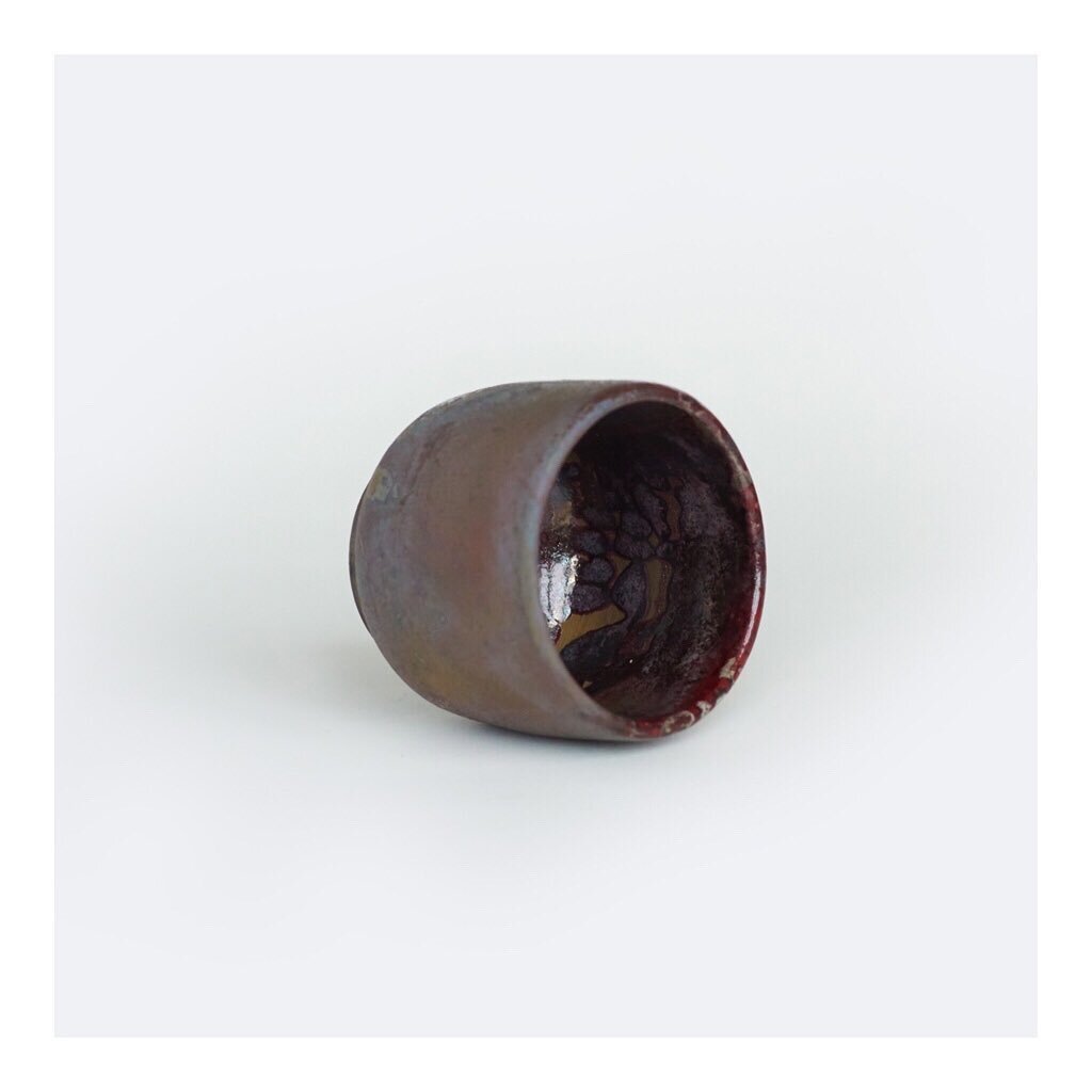 P R I N C E cup. This one-of-a-kind Raku cup has so many moods. 🔮 The purples in this piece make it feel regal and the unexpected patterns so mesmerizing. Metallic rainbow colors are exemplary of the Raku technique - the low-fire process that create