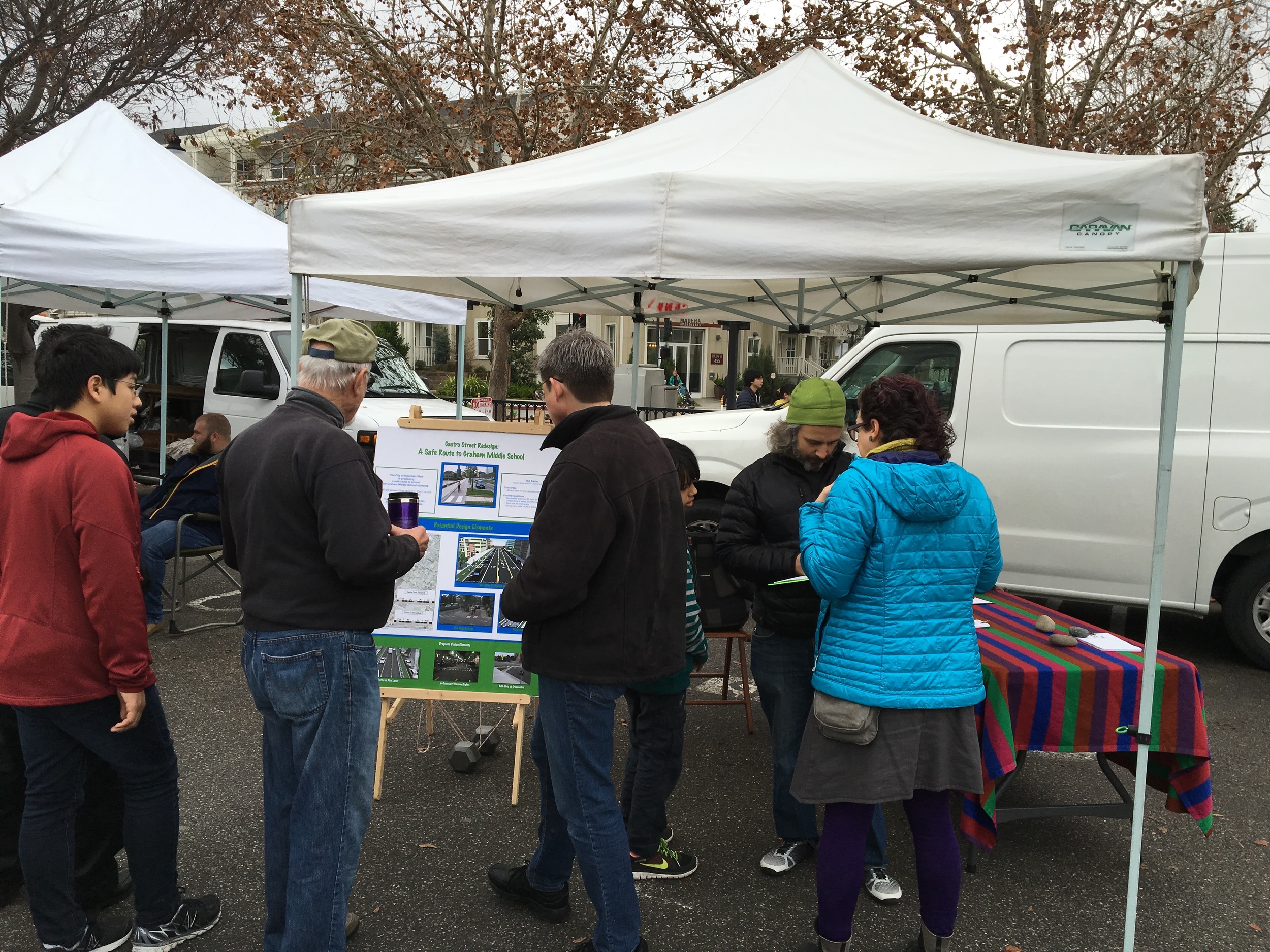 Patrick discusses the proposed improvements with one person and Trish helps another sign up.
