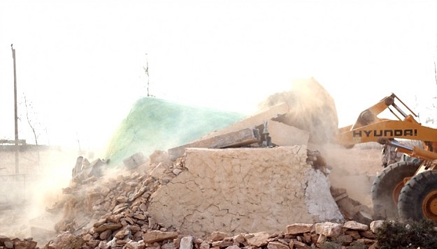 ISLAM FANATICS ULTIMATING THE SHRINES' DESTRUCTION WITH A DIGGER. PHOTO CREDIT: THE GUARDIAN