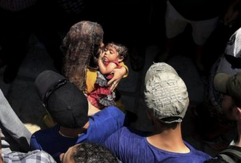 Migrant Crowds Create Passage for Women and Children to Move Through