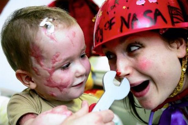 A clown doctor playing with a young patient. Credit: Manchestereveningnews.co.uk