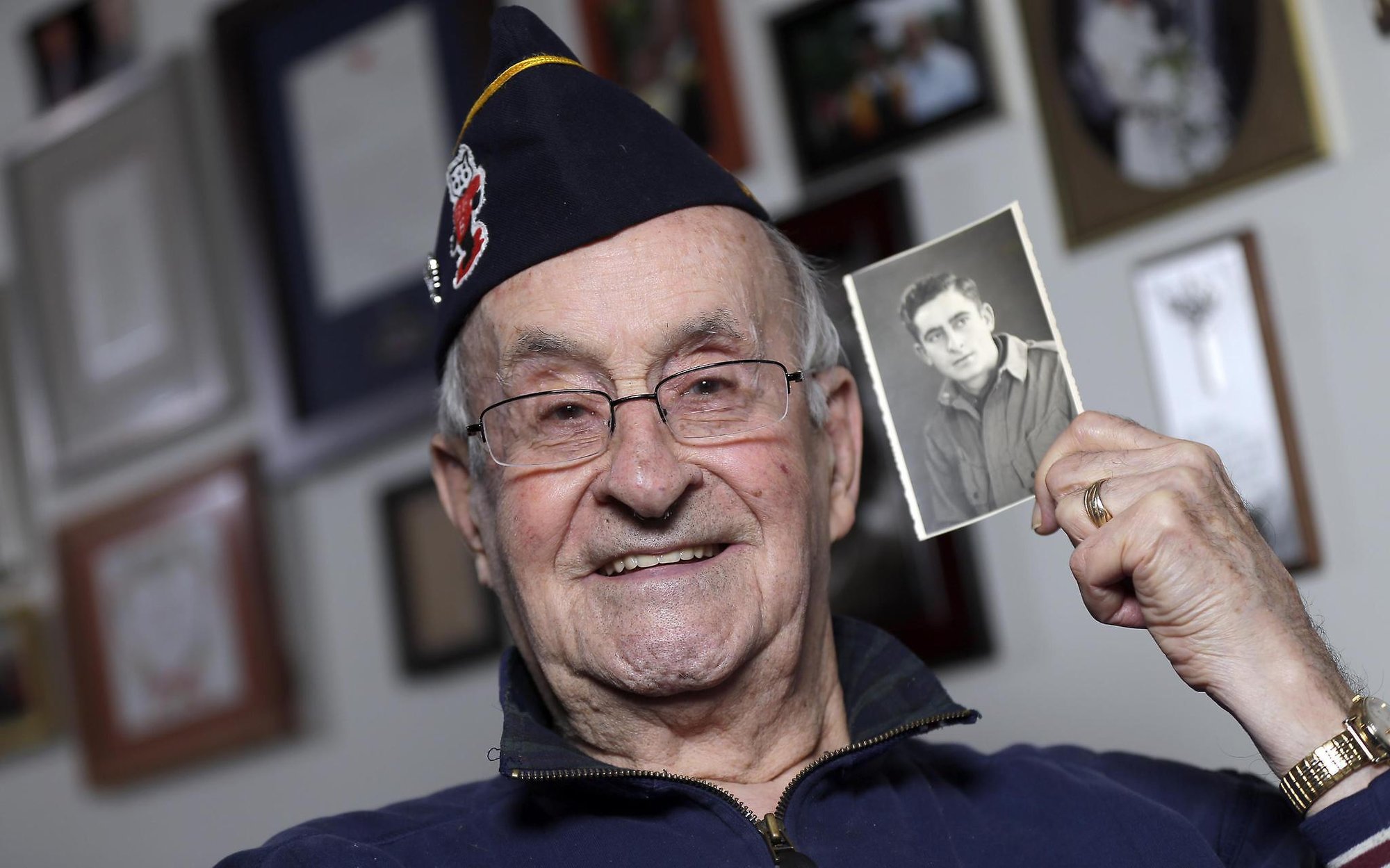 World War II veteran Ralph Ticcioni, 93, showing a photo of his younger self as a soldier. Credit: Media.jrn.com ( full link )