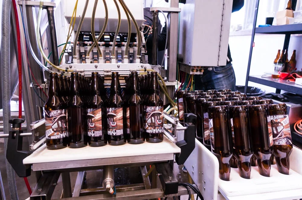 Labeled bottles entering the filler