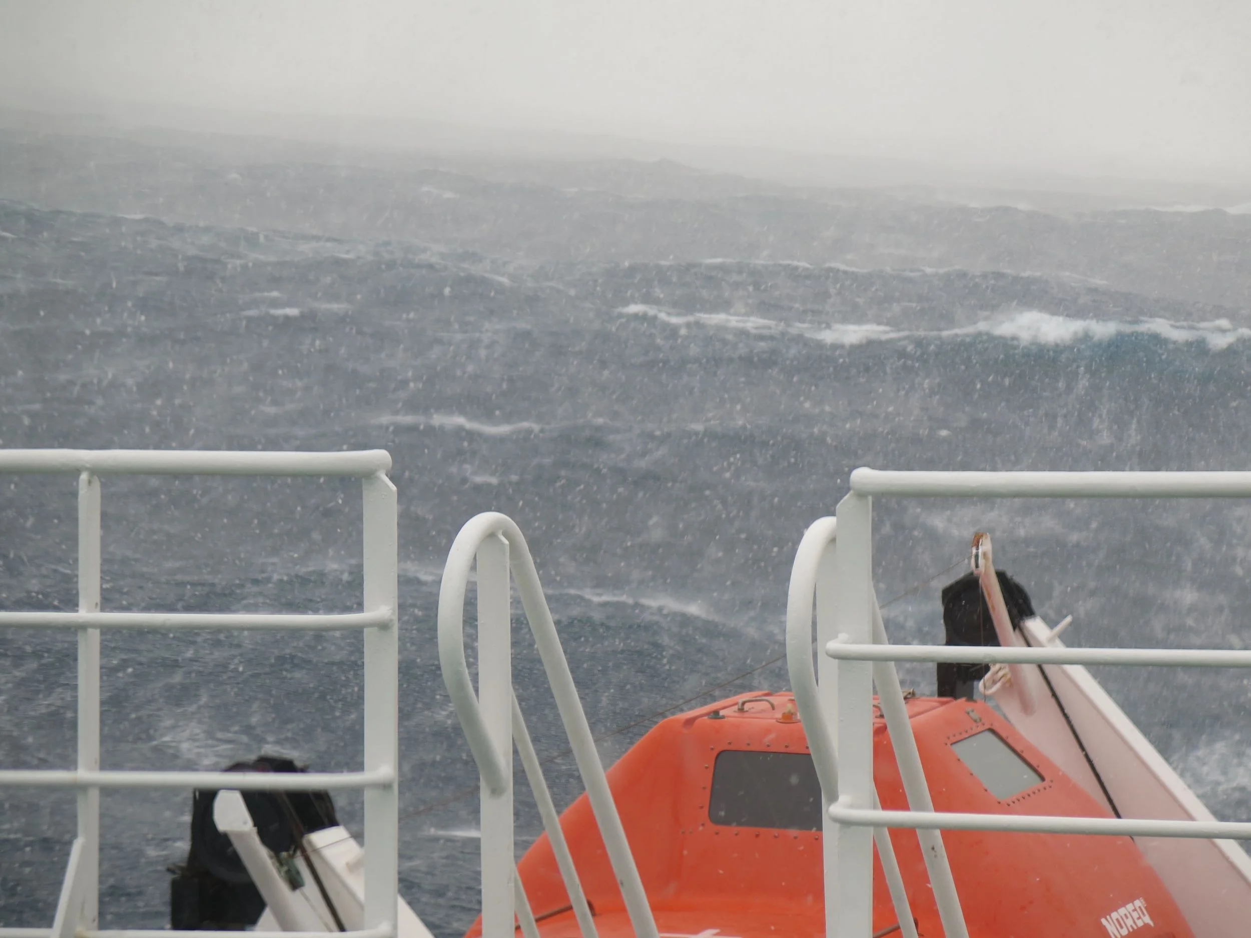 ...and oh, yeah, it started to snow heavily. That orange pod is one of the lifeboats, designed to sardine-pack 56 passengers, an adventure we hoped not to experience.