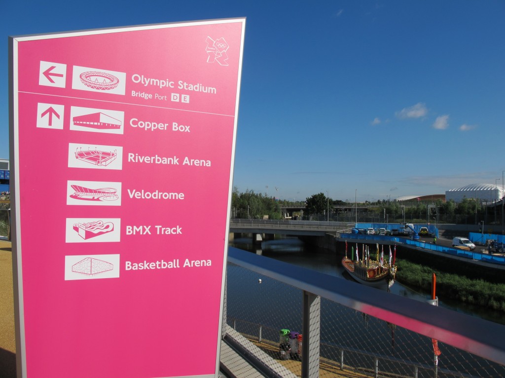 The park has streams, bridges and restored wetlands. The basketball arena is in the distance to the right, with the cycling velodrome to its left.