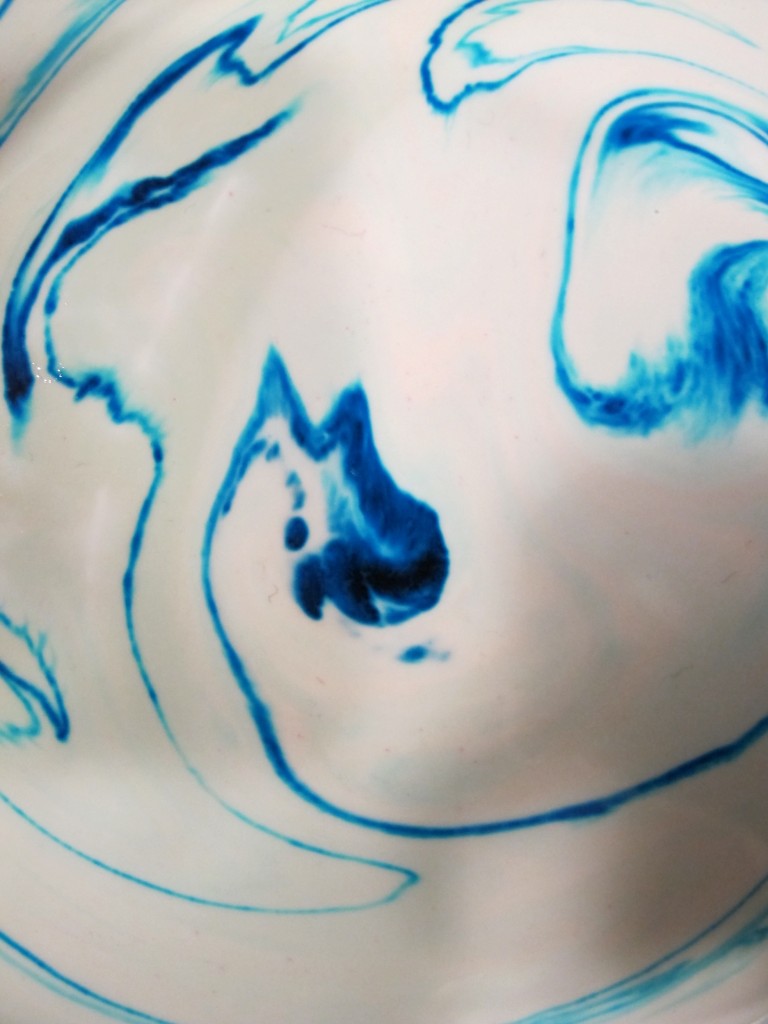 From the surface emerged a blue bird's head, facing up, with its beak open.