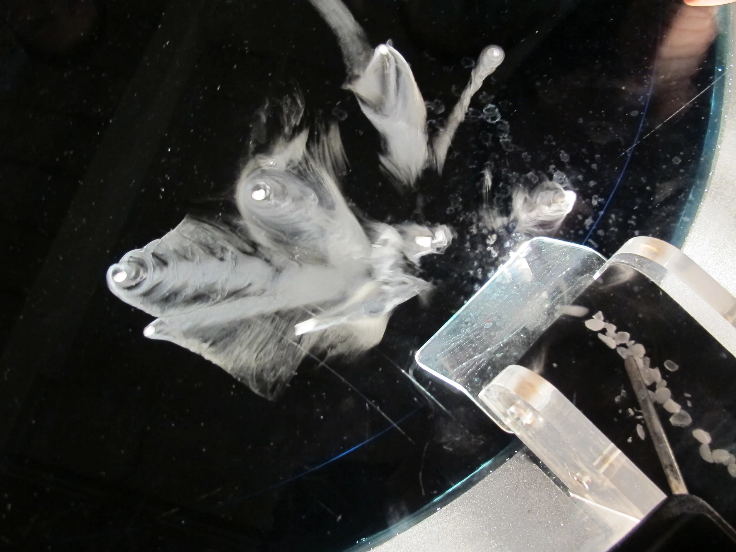 Here's how the installation worked: Pieces of dry ice fell from an elevated runway (right) onto the water and immediately reacted by spiraling and rocketing across the surface in a vivid release of energy.