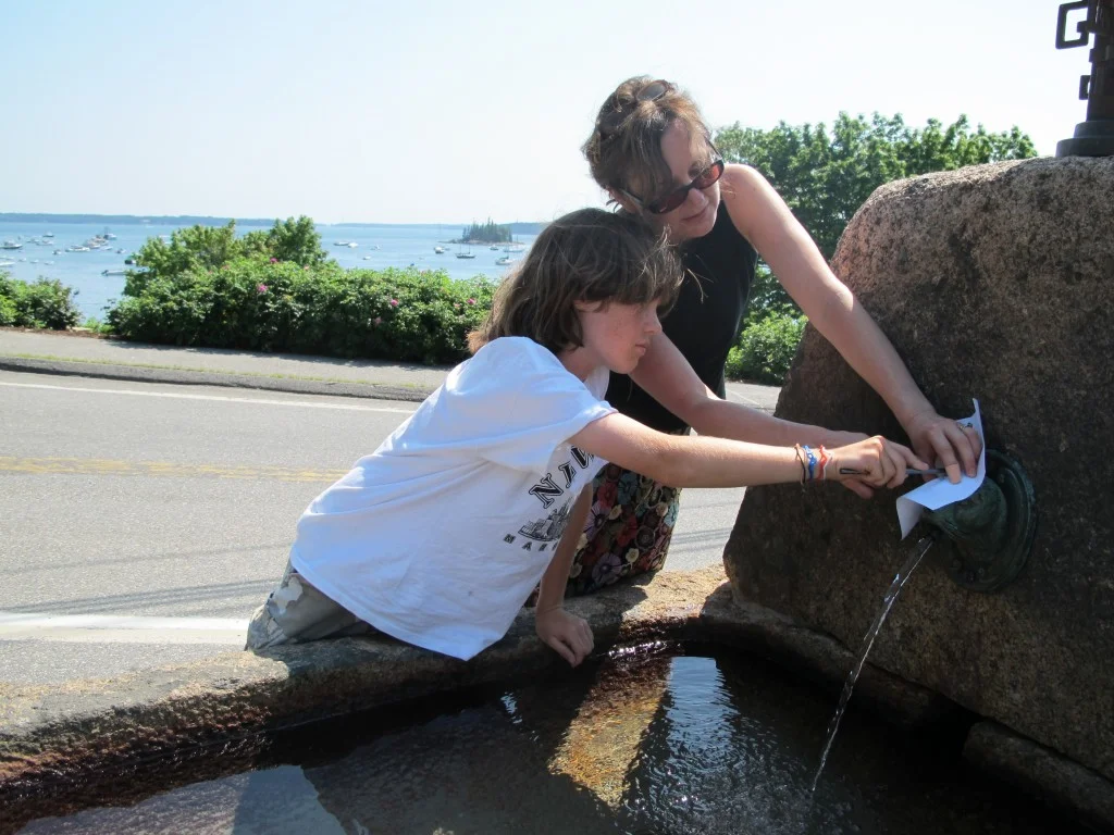 Pamelia helped hold the paper for the youngest artist, Noah, as he did a rubbing on the Seal Harbor fountain.