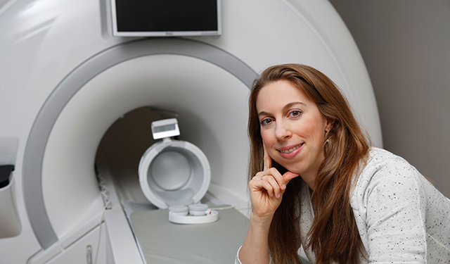 Dr. Losin poses for a photo with the mock MRI scanner.