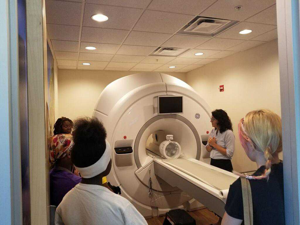 The tour included a viewing of the Neuroscience Annex’s mock fMRI scanner accompanied by a detailed explanation of brain imaging by facility assistant director, Dr. Ekaterina Denkova (standing at right).