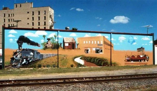 The Early Days mural faces the tracks on which the train arrived in 1904.