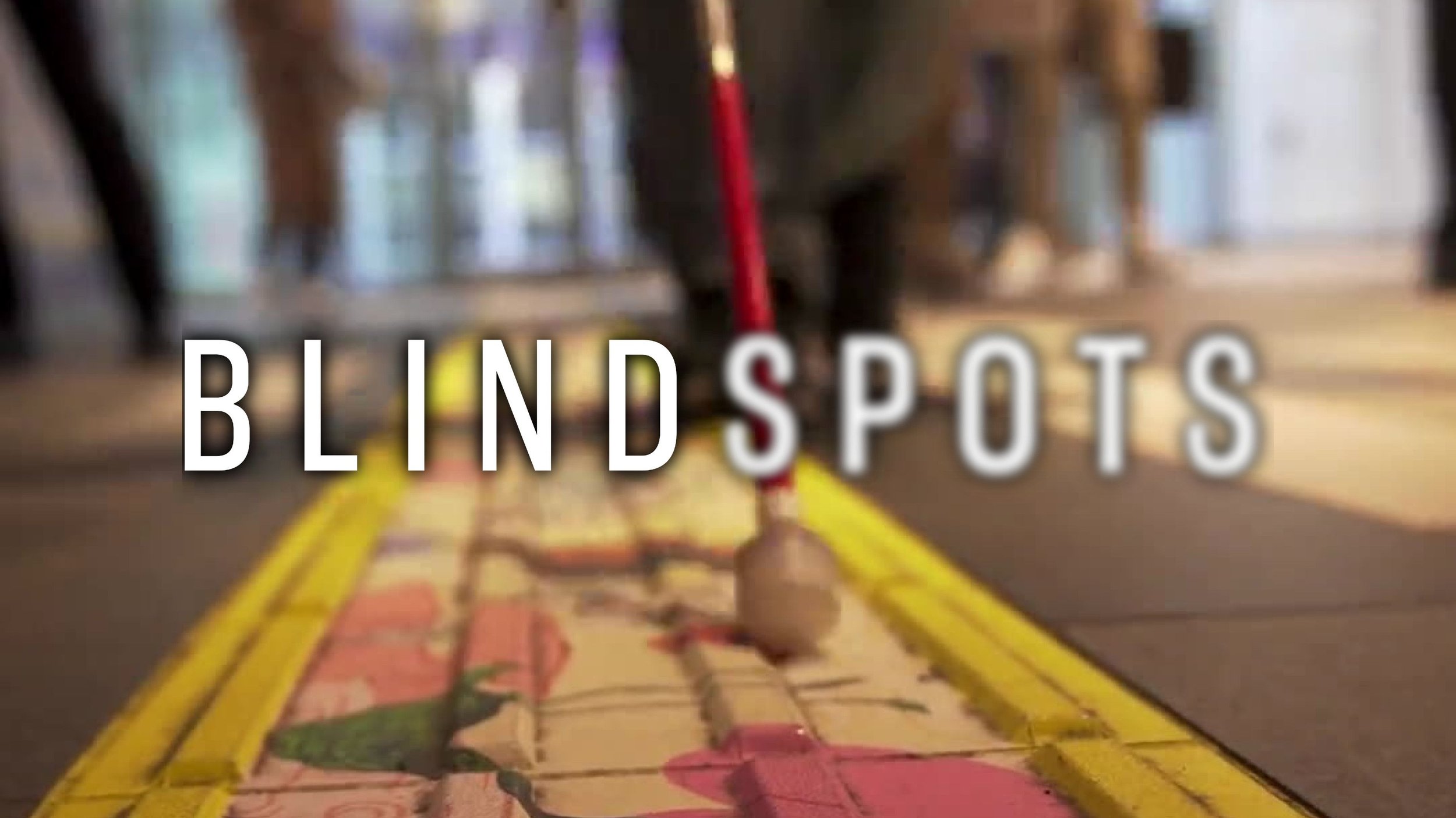 On a Tokyo sidewalk, a White Cane slides through a vibrantly colored accessible pathway. The Blindspots logo is overlaid. Spots is slightly blurred.