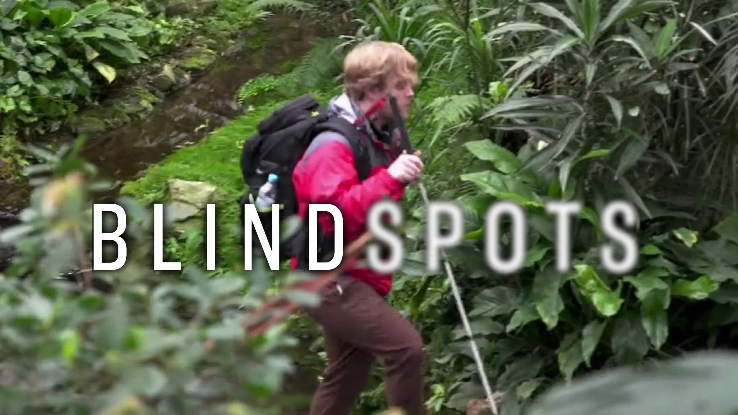 James Rath walks through a vibrant garden filled with plants. The Blindspots logo is overlaid. Spots is slightly blurred.