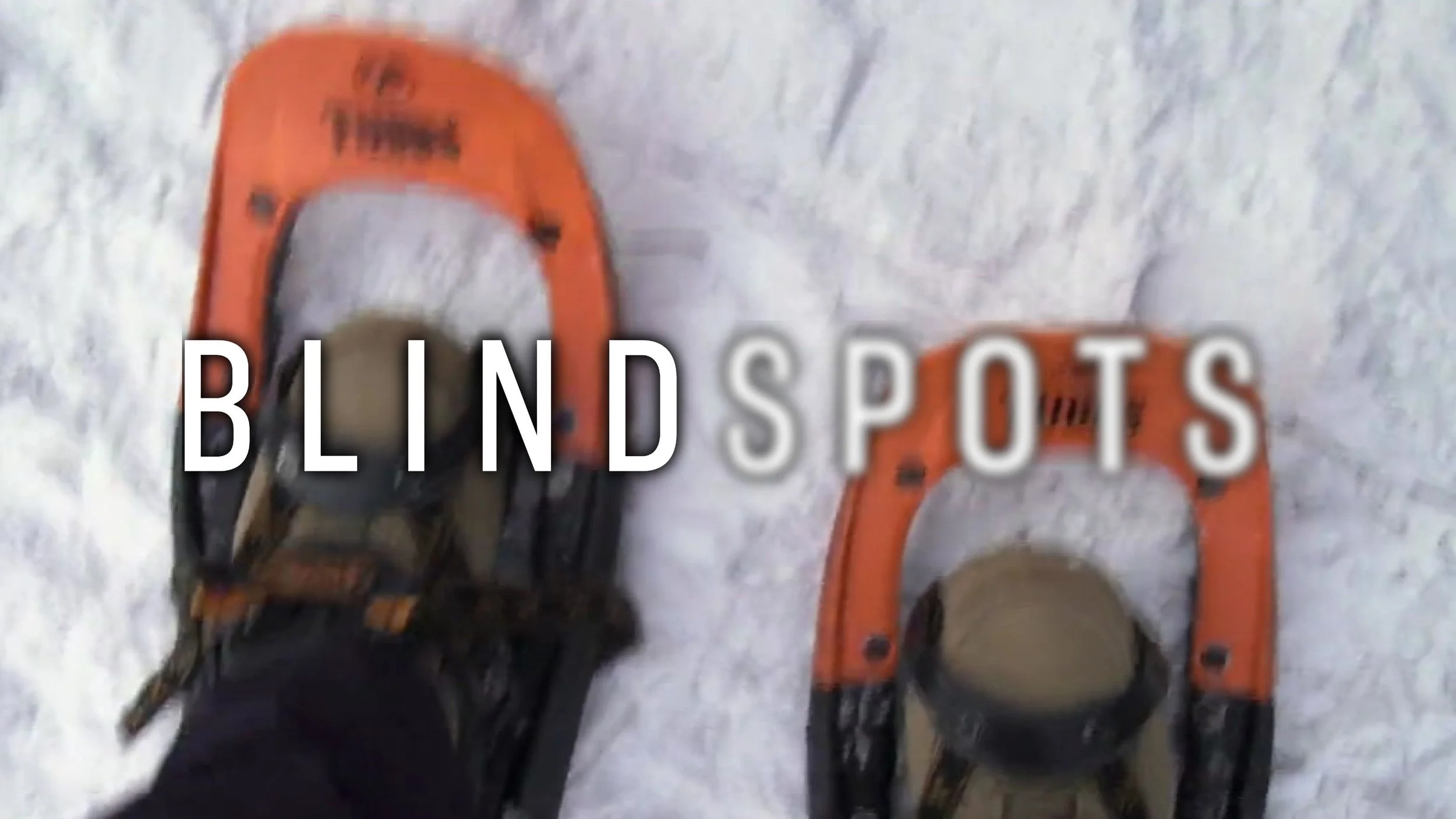 From James Rath's perspective, looking down at snow shoes digging into thick snow. The Blindspots logo is overlaid. Spots is slightly blurred.