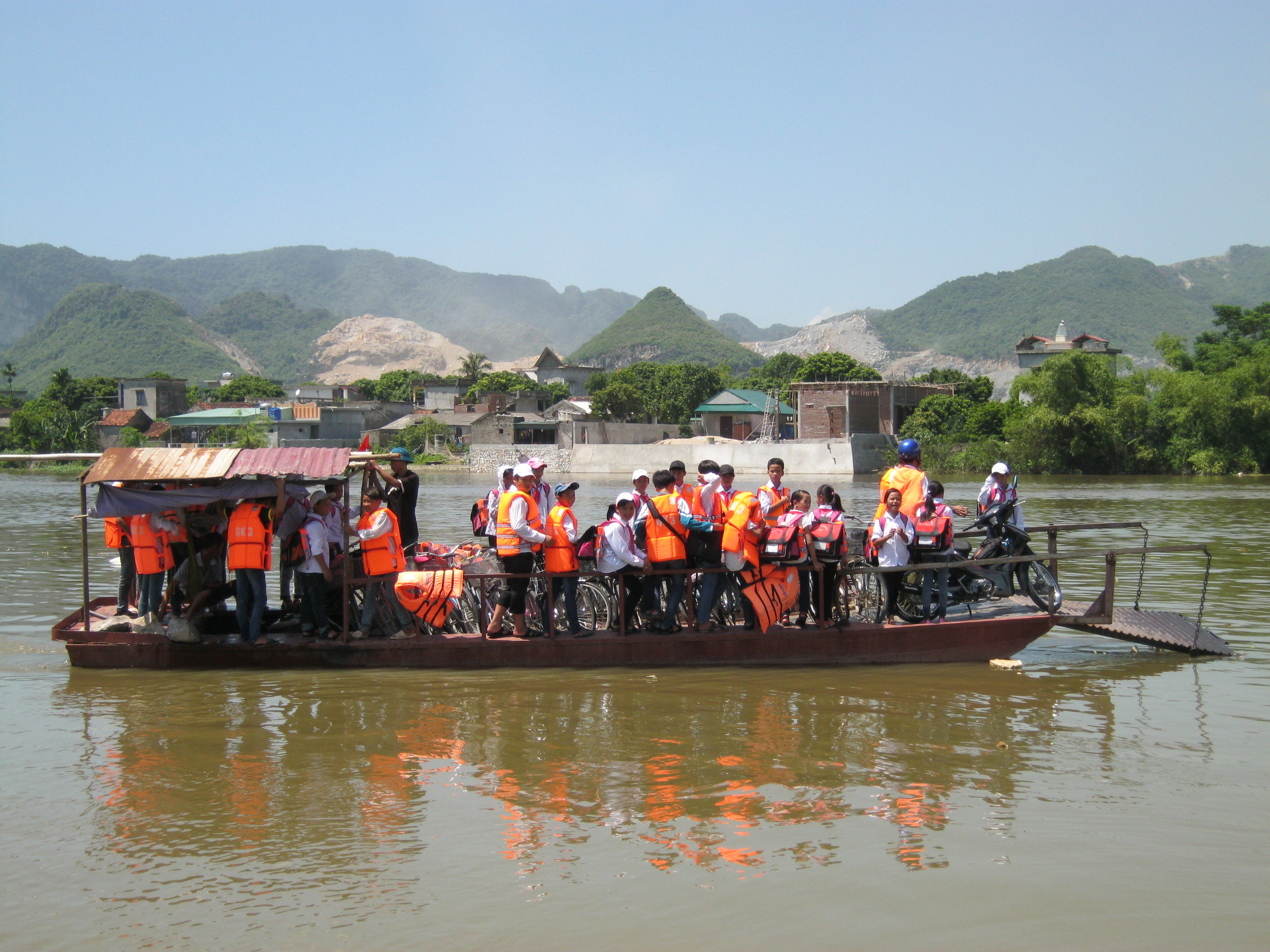 Students crossing the river on daily commute to and from school using a "safer" boat.