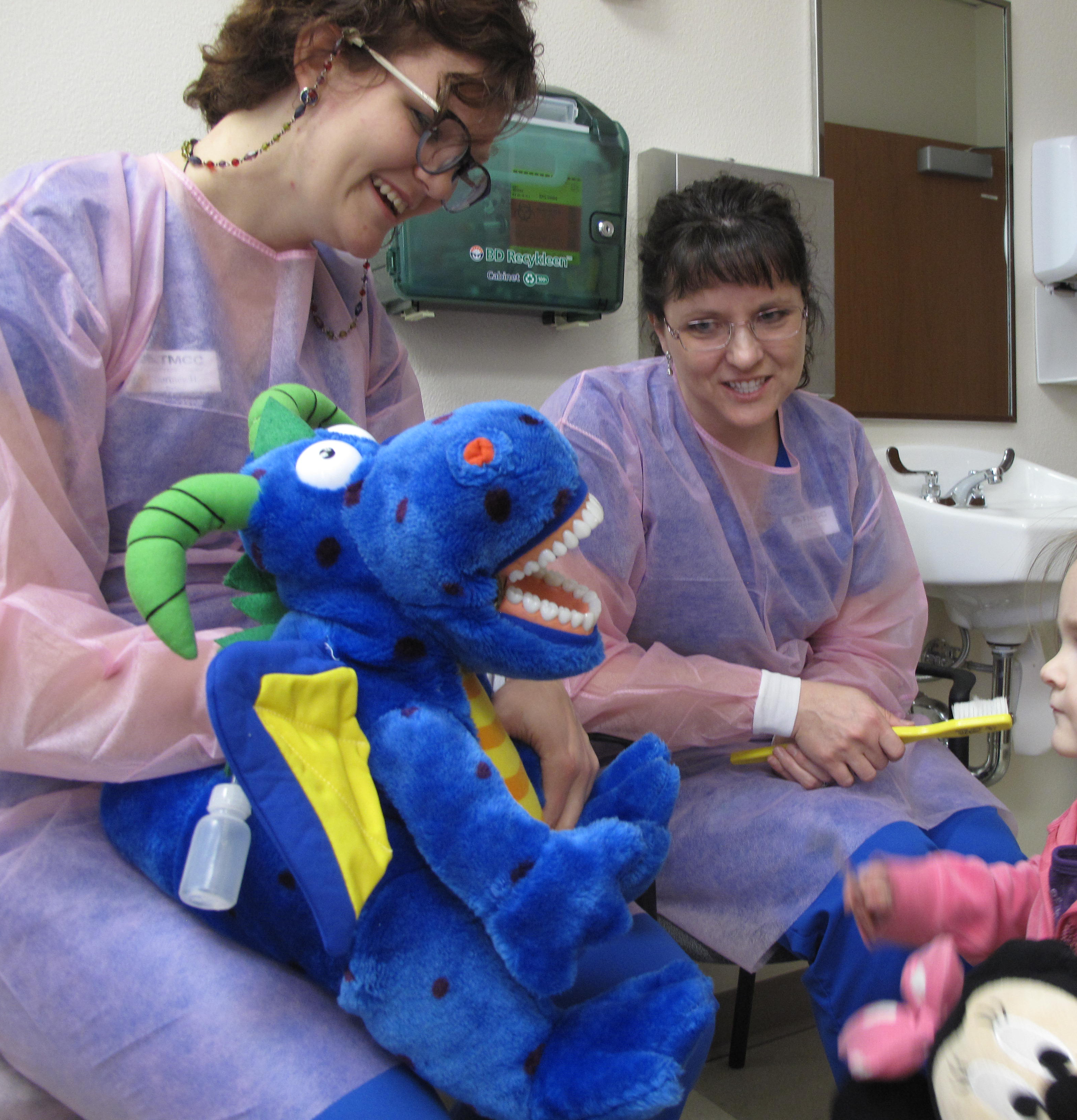 Volunteer dental practitioners conduct oral health education activities with children participants in pilot program