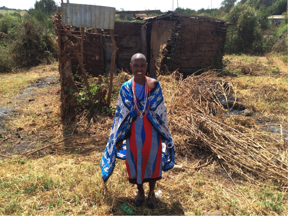 Maitei standing in front of her prior home.