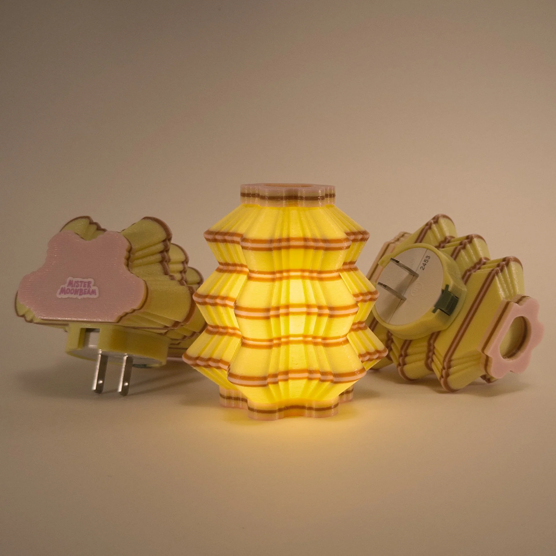 Three Scallops night lights in yellow, brown, and pink, glowing