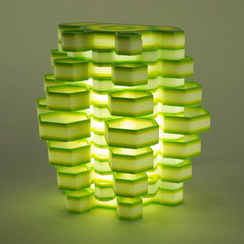 Single Hexy night light in green and yellow, glowing