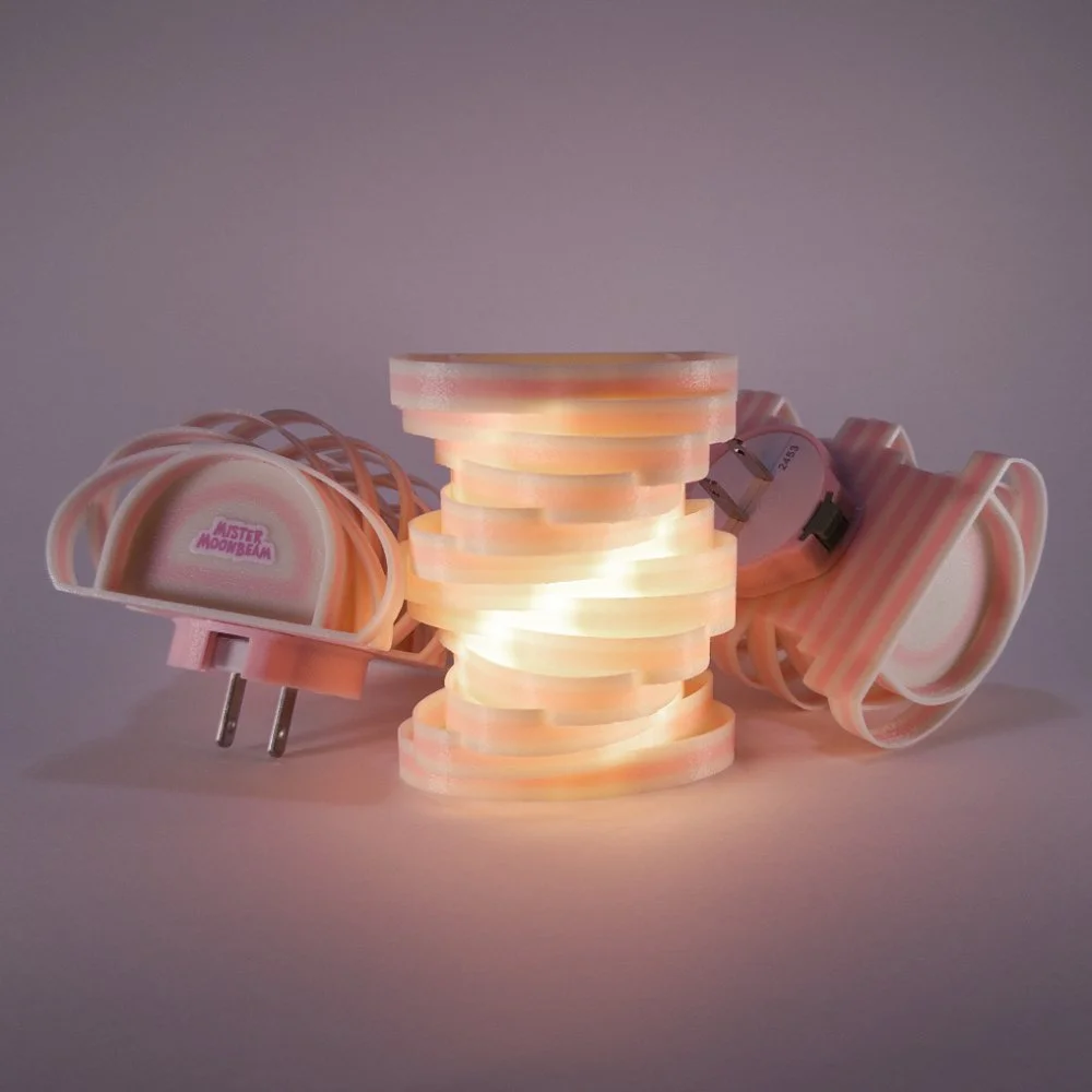 Three Spinoval night lights in pink, glowing
