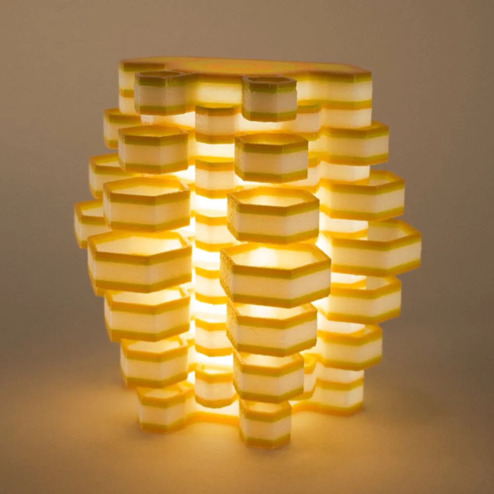 Single Hexy night light in orange and yellow, glowing