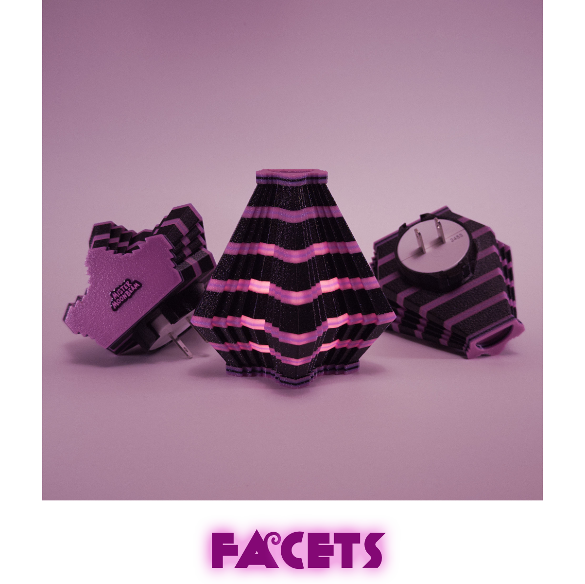 Three Facets night lights in black and pink, one glowing, with plug prongs visible