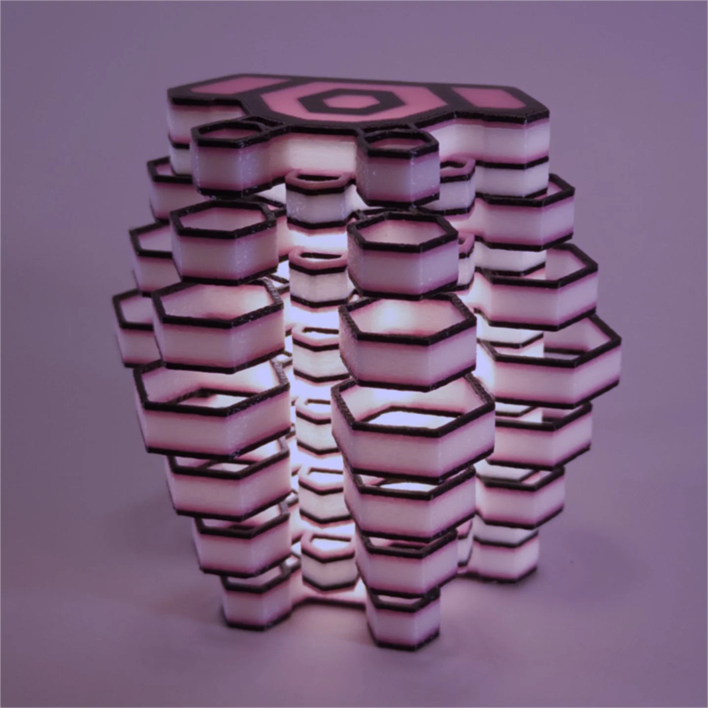 Single Hexy night light in black and pink, lit up