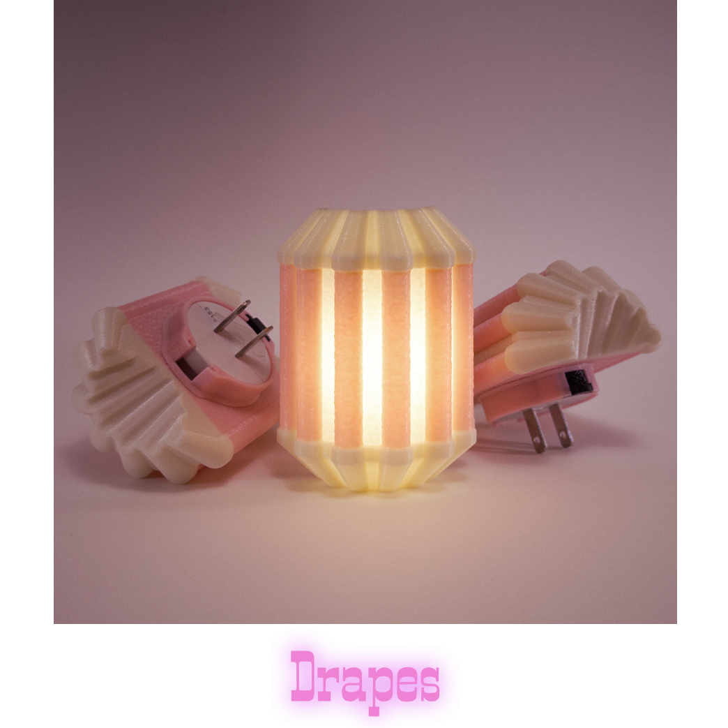 Three Drapes night lights in pink, one glowing, with plug prongs visible
