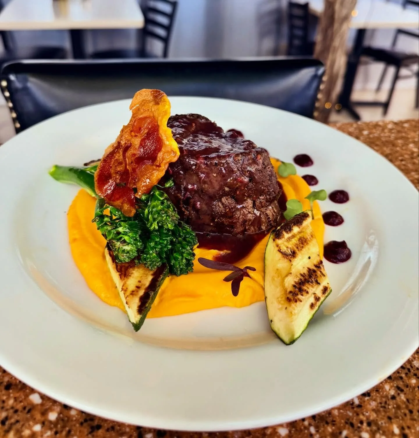 Steak Special: 8 oz Filet Mignon, served with a silky carrot pur&eacute;e, grilled zucchini and broccolini, topped with crispy pancetta and finished with a berry demi-glace