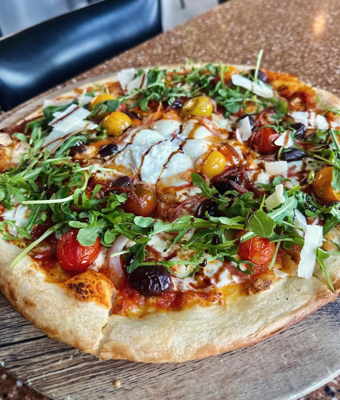 🇮🇹New Pizza: House-made red pepper sauce layered with fresh mozzarella and creamy burrata, topped with salami, Kalamata olives, and red onion, roasted heirloom cherry tomatoes. Finished with arugula, Mediterranean herbs, and a drizzle of black garl