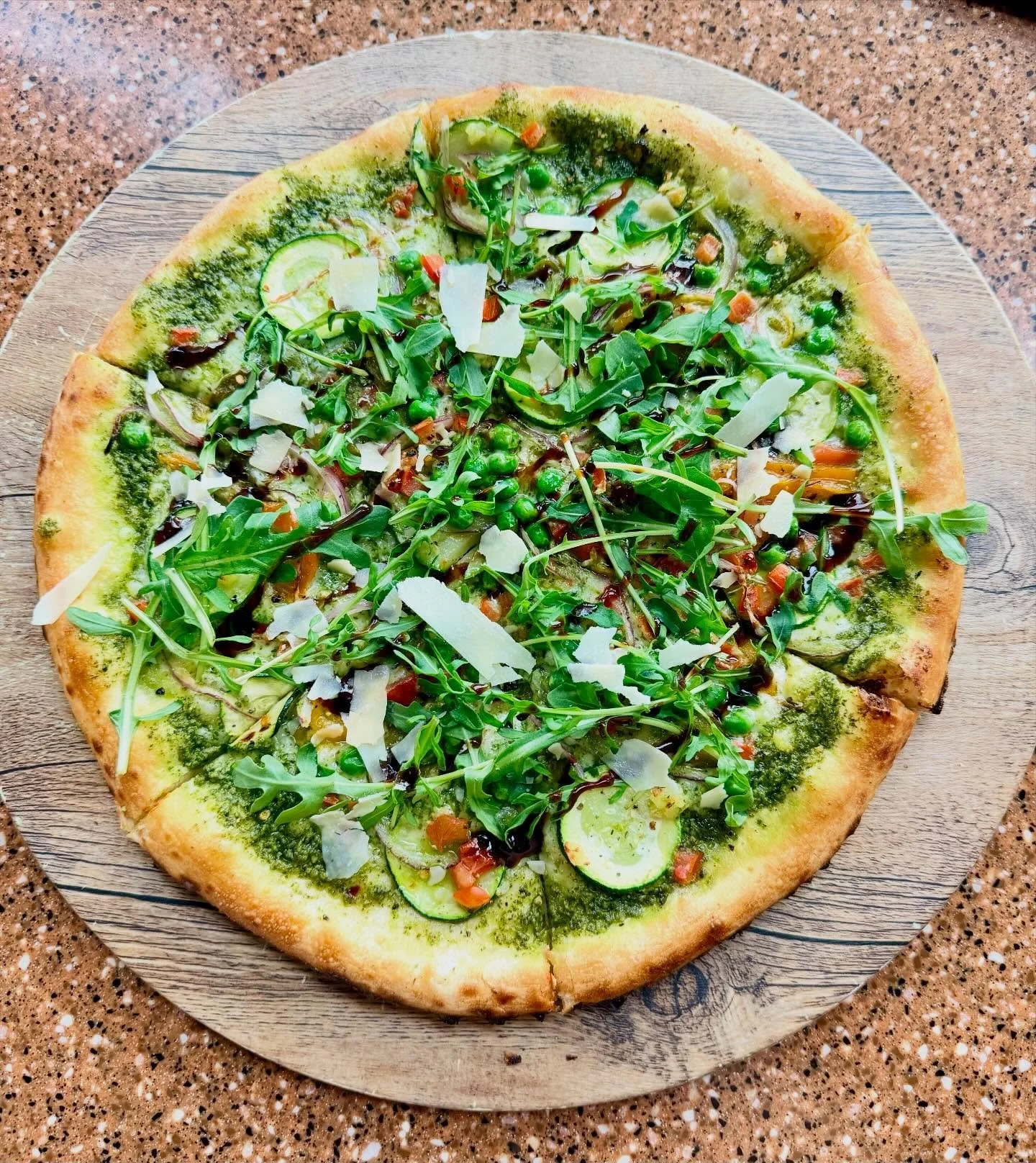 🌿 NEW PIZZA SPECIAL &mdash; Pesto Bianco Pizza 🌿

Straight from our oven to your table! Fresh, vibrant, and layered with flavor.
A pesto base topped with fontina cheese, roasted bell peppers, zucchini, confit garlic, red onion, green peas, and dice