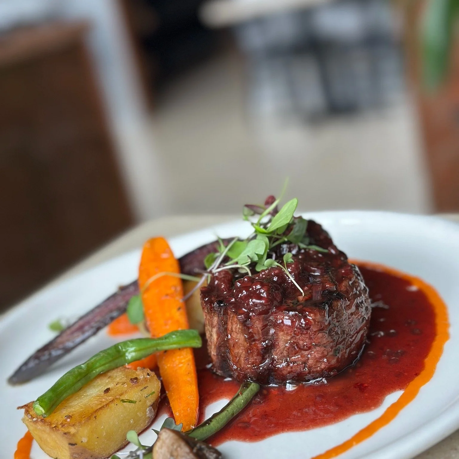 Our May Steak Special features a perfectly grilled 9oz filet mignon served over silky carrot pur&eacute;e with pan-roasted Yukon gold potatoes, heirloom carrots, seared mushrooms, and green beans, all finished with a rich blackberry demi-glace.