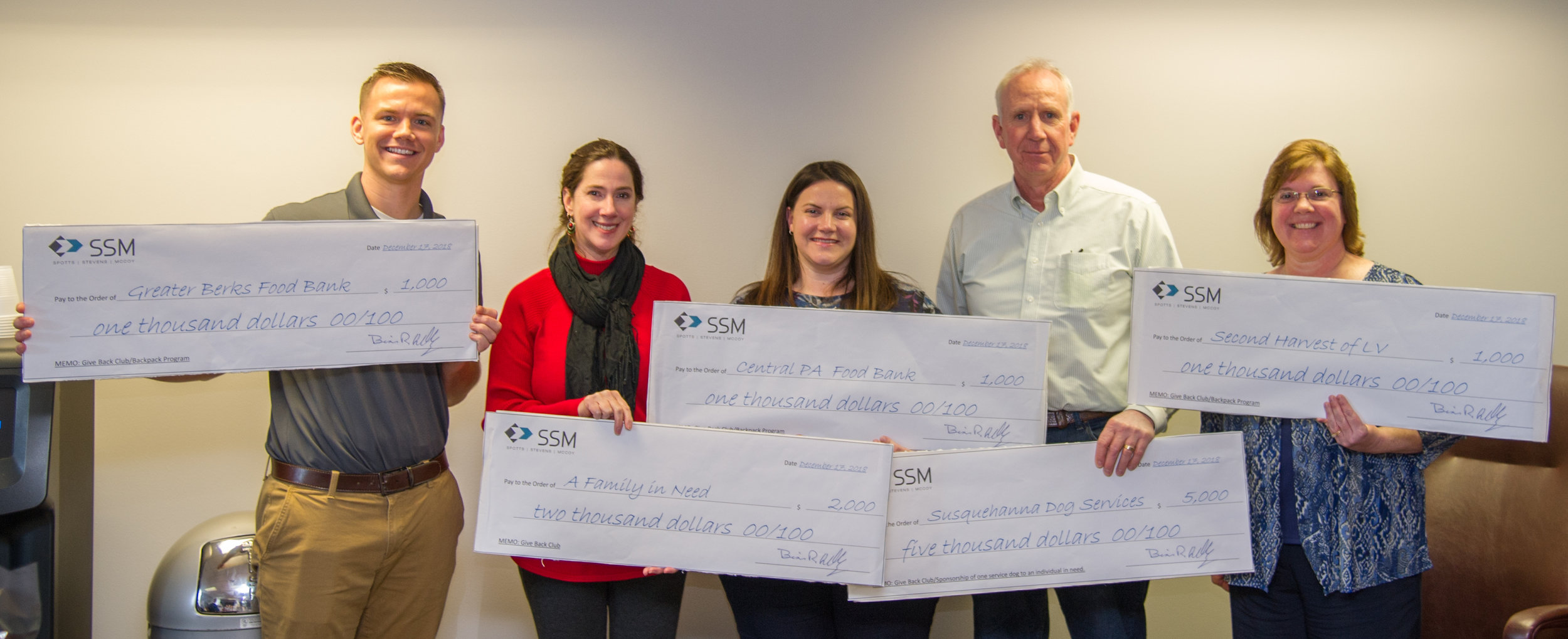 Members of the SSM Give Back Club (left to right: Nick Szeredai, PE, Lyn O’Hare, Michelle Hohl, PE, Steve Smith, and Michele Eidle) display checks representing the firm’s $10,000 donations.