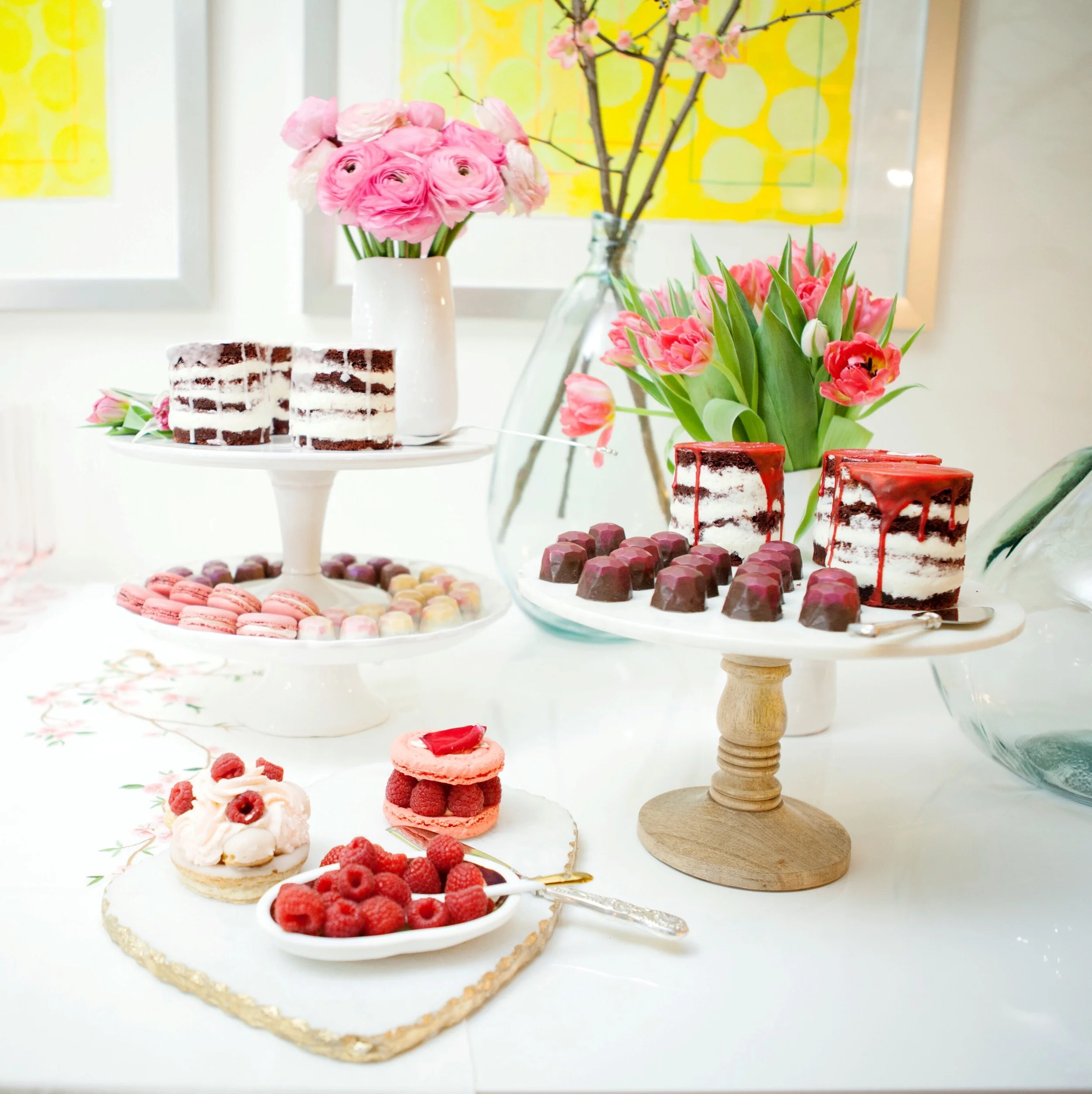 A variety of serving pieces and cake stands provides depth and height to the display.