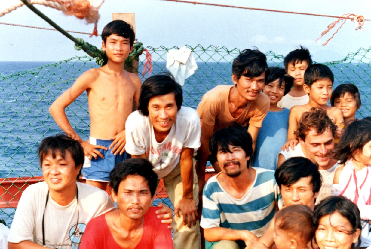  Refugees on the CA ÌI deck. Dương Phuc (wearing camera) and Nguyễn &nbsp;Hữu Huấn (Cap Anamur T shirt) &amp; Nguyển Tất Hiền (blue striped T-shirt). 