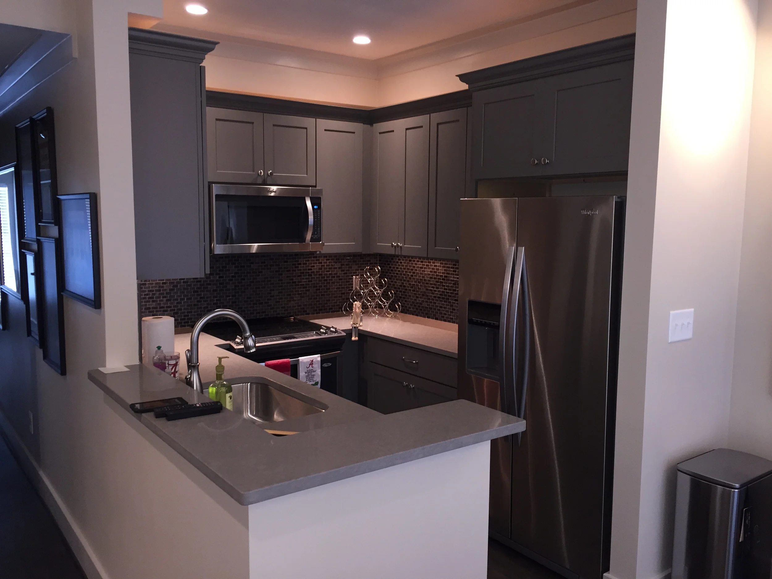 Updated kitchen with SS appliances, quartz tops, glass mosaic splashes, and special lighting.