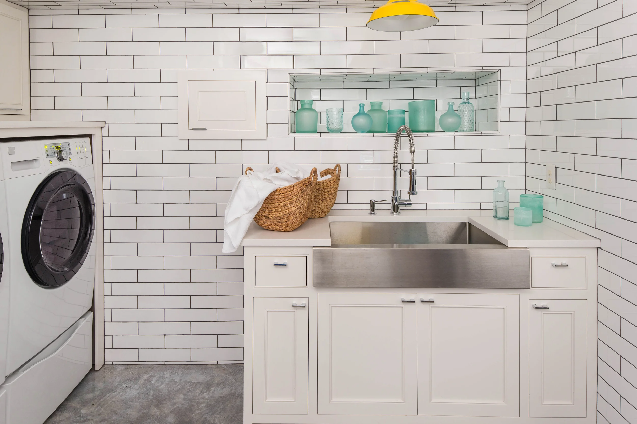 Full laundry with floor to ceiling tile and opposing wall Service Space.