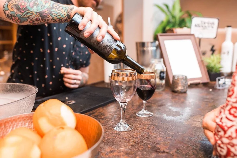 Red wine being poured at the bar