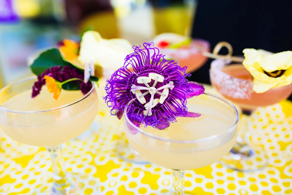 Cocktails garnished with purple edible flowers at a Bumble event