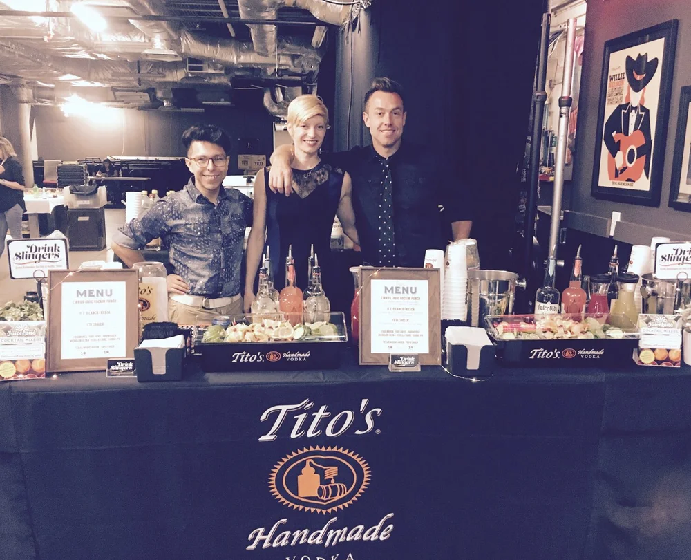 A team of bartenders behind a sponsored Tito’s bar