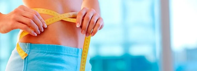 woman measuring her waist with a tape measure.jpg