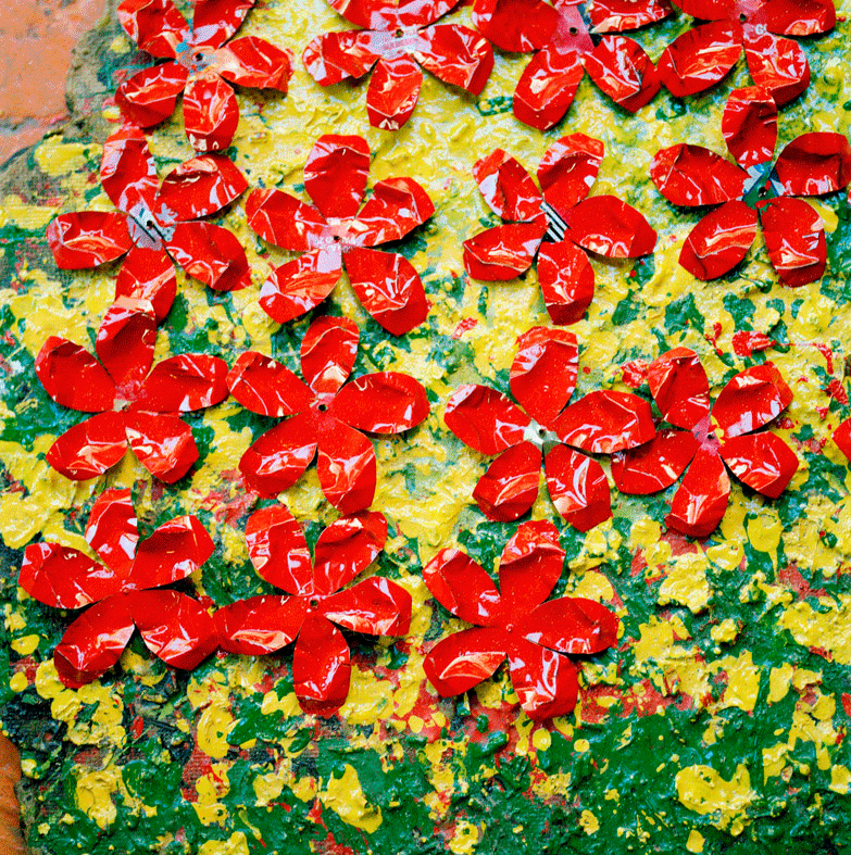 "One night I dreamed of a rubbish dump filled with yellow and white flowers, and a voice told me to pick and sell them and I would have money for food. When I woke up I walked to Swartklip, where the refuse of Cape Town is tipped into the dunes. I wandered in the rubbish, but I found nothing. Some weeks later I dreamed the same dream. Again I went in search of flowers, but returned home disappointed, empty-handed. When the dream came back for the third time, I feared I was losing my sanity and that the desperation of my circumstances was playing tricks with my mind. I returned to the dump. This time, in the course of my searching, I noticed piles of empty soft-drink cans, yellow and white. I gathered up a few and hurried home. In my shack I set to work with a pair of scissors and a pot of paint. After many setbacks I finally fashioned a flower just like the ones in this dream: A perfect daisy with a long green stem, pointed white petals and a yellow centre. Then I decided to follow my dream." Sonwabo Golden Nongawuza (1957) Photo by Knut Egil Wang