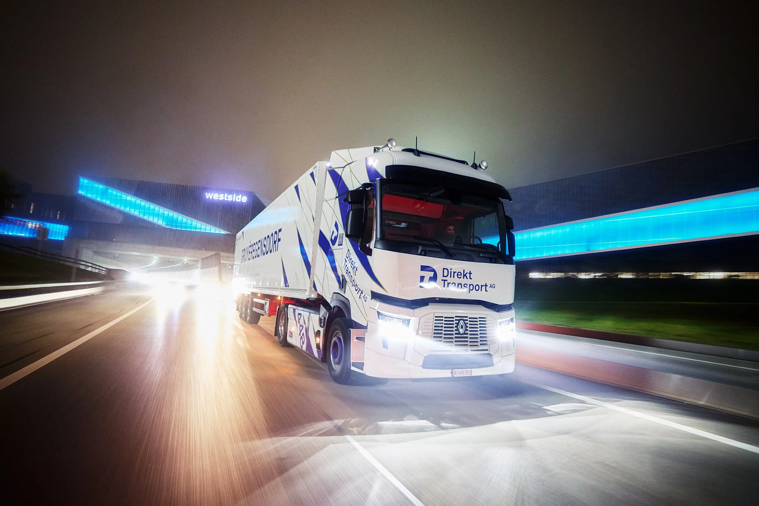  Lastwagen der Firma Direkt Transport während der Fahrt auf der Autobahn. Fotografiert während der Blauen Stunde in der Naähe von Bern 