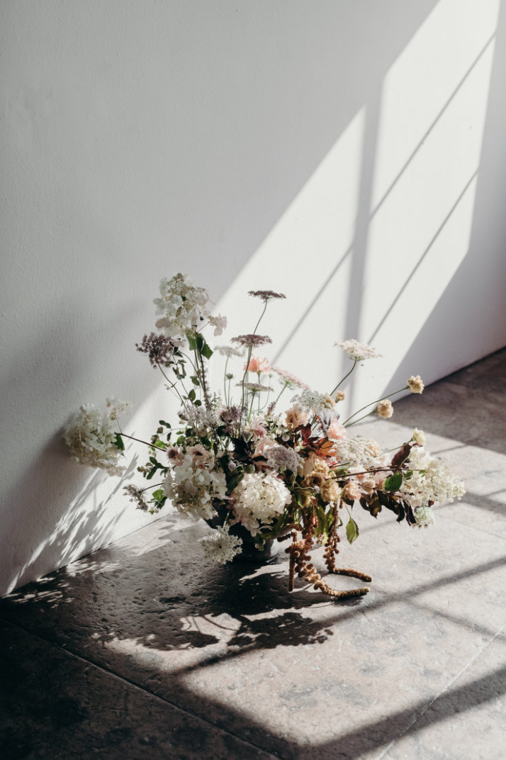 Sammy Go Lambert - this compote vase arrangement makes me feel like a little girl running through a wild field of flowers at the end of summer as the sun is setting. such a unique use of height variation and at random points. It has a perfect resemblance to a wild field of flowers. 