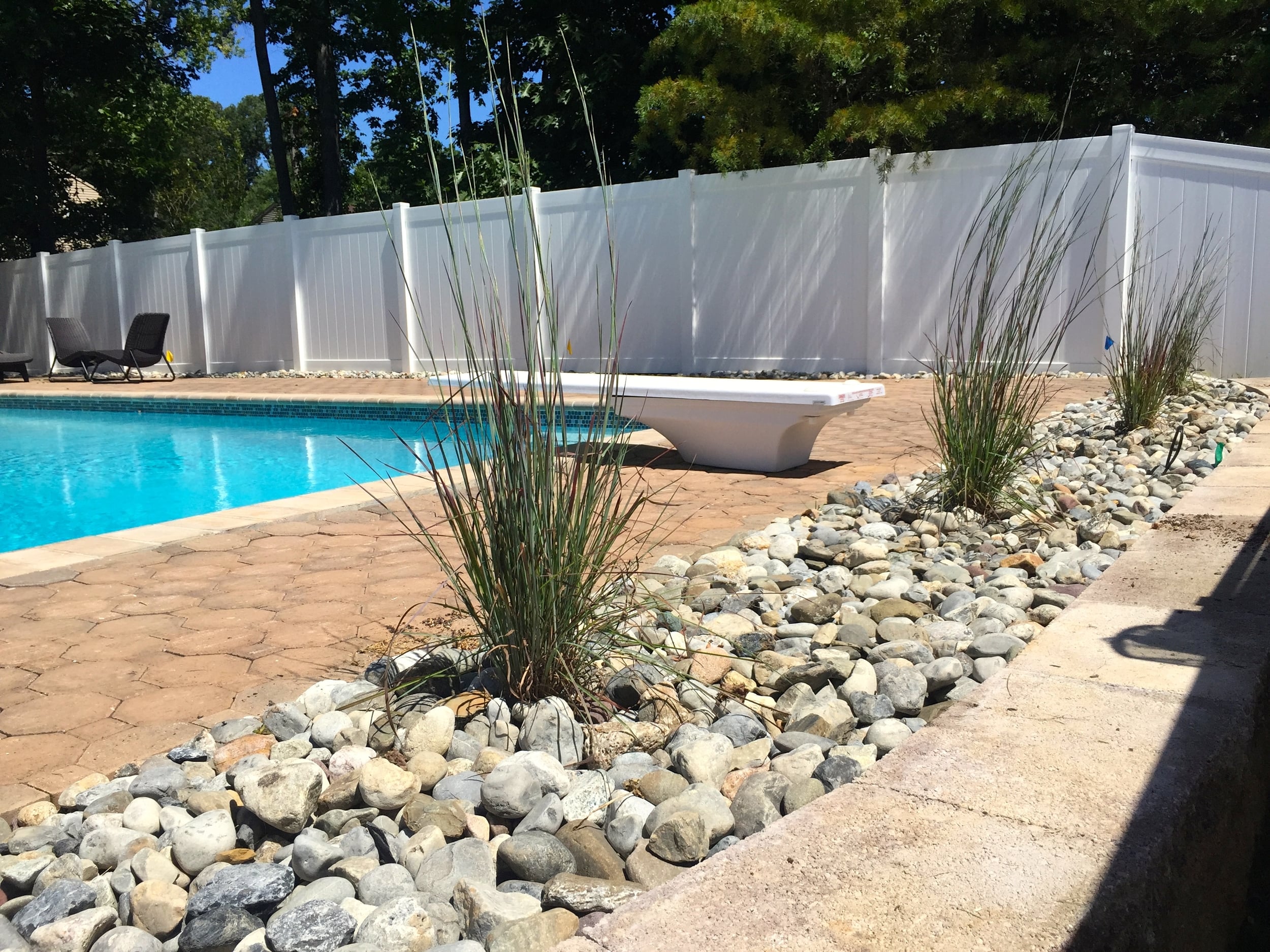 Ornamental Grass w/ river rock by the pool Design by jason t.