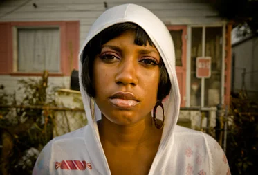 "Girl in a Hoodie in Front of a Pink and White House"