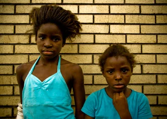 Two Girls in Front of a Brick Wall