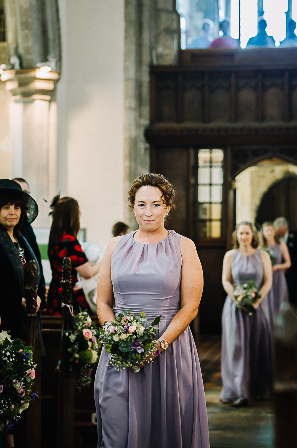 Bridesmaid Walking Down the Aisle at Cottenham All Saint’s Church - Swynford Manor Wedding Photographer