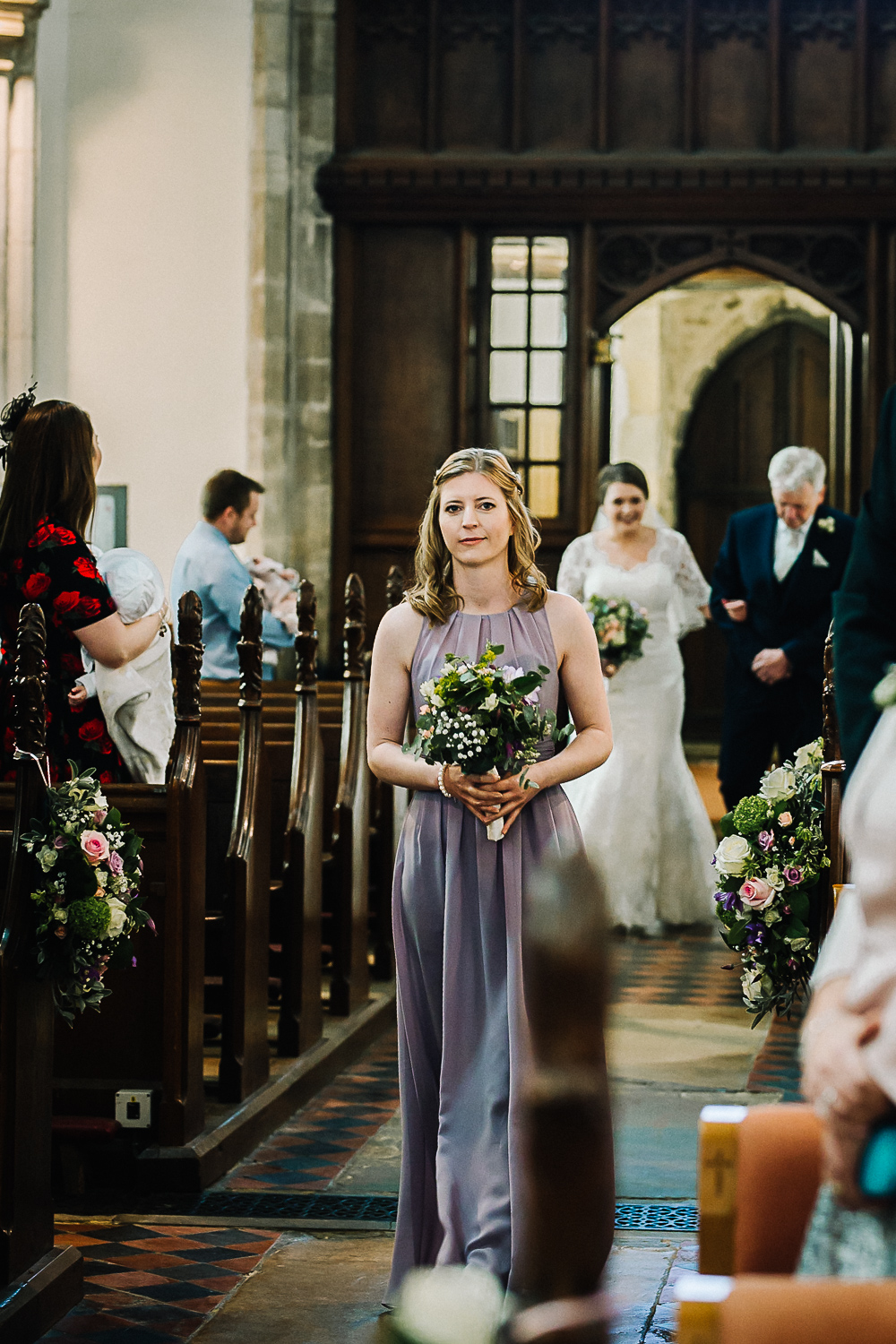 Bridesmaid Walking Down the Aisle at Cottenham All Saint’s Church - Swynford Manor Wedding Photographer