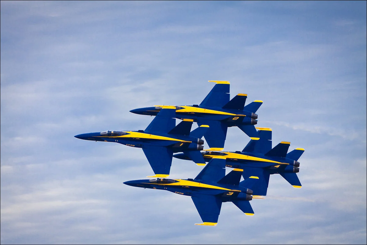  Four of the six members fly by in a tight Diamond formation.